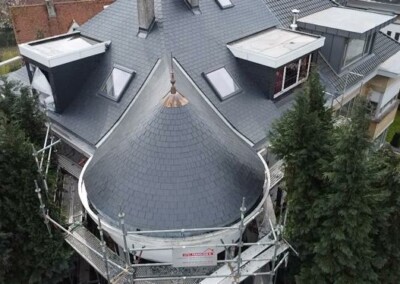 Rénovation terminée de l'isolation d'une toiture en tuiles noires d'une maison à Boitsfort