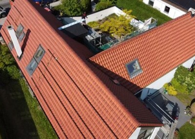 Rénovation terminée de la toiture en tuiles rouges d'une maison en forme de L