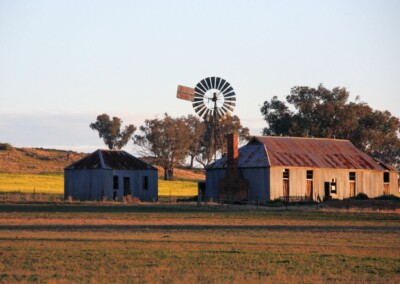 Une annexe de maison en tôle et un moulin à vent en arrière-plan
